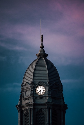 Image : un clocher avec une horloge présentant le temps qui passe - Procrastination- epnll -Ecole de PNL de Lausanne.- Valéry Comte